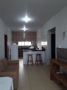 a living room with a couch and a kitchen at POUSADA ROSA MAR in Luis Correia