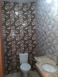 La salle de bains est pourvue de toilettes et d'un lavabo. dans l'établissement POUSADA ROSA MAR, à Luis Correia
