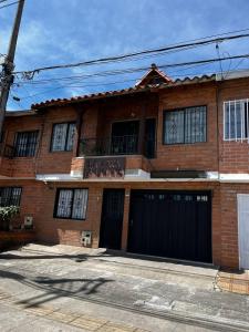 a brick house with two garage doors and a balcony at Letto Hostal in Rionegro