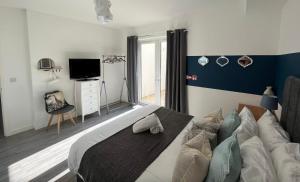 a bedroom with a large bed and a television at Sunnyside Studio in Worthing