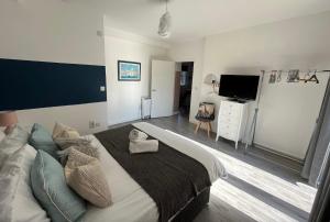 a bedroom with a large bed and a flat screen tv at Sunnyside Studio in Worthing