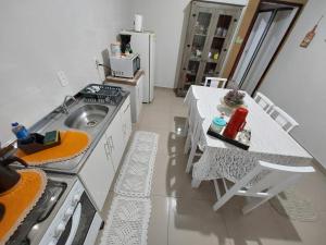 a kitchen with a sink and a table with chairs at Harmonia Haus in Blumenau