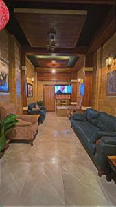 a living room with couches and a flat screen tv at Al-Naher Al-Khaled Hotel in Aqaba