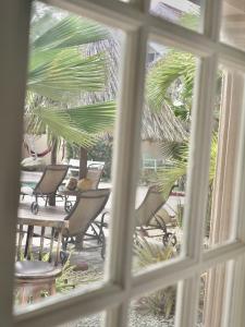 a view of chairs and tables from a window at Aruba Tropic Apartments in Noord