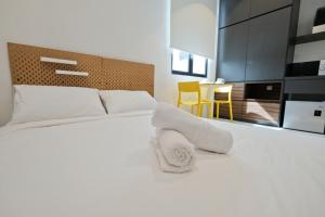 ein Schlafzimmer mit einem Bett mit weißen Handtüchern darauf in der Unterkunft ALOR SETAR IMPERIO PROFESSIONAL by ZUES in Alor Setar