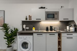 a kitchen with a washing machine and a microwave at BRIGHT Lippstadt Klusetor in Lippstadt