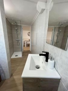 a white bathroom with a sink and a shower at Apartamento playa Vigo in Vigo