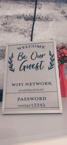 un signo que dice bienvenido sea nuestro invitado con el resentimiento de la red administrador resistente en Apartment Center 23, en Podgorica