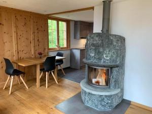a living room with a stone fireplace in a kitchen at Neuwertiges 2-Zi-Ferienchalet 55m2 in Monstein