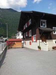 a black and white building with red shuttered windows at Ferienwohnung Uhu in Altdorf