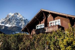 a house with a balcony with a mountain in the background at Ferienwohnung Uhu in Altdorf