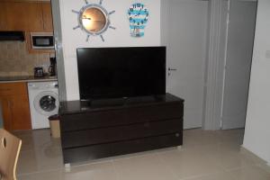 uma televisão em cima de uma cómoda numa cozinha em Apartment Ground Floor, FREE INTERNET em Agia Napa