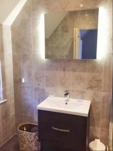 a bathroom with a sink and a mirror at Avis Hotel in Bromley