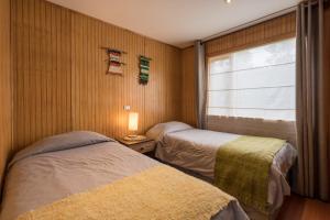 Giường trong phòng chung tại Cabañas Torre Huillinco +108 ảnh