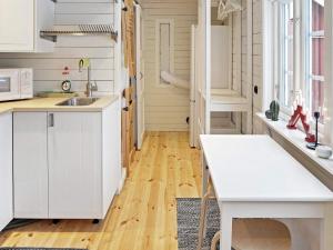 una cucina con armadietti bianchi e pavimenti in legno di 4 person holiday home in GRISSLEHAMN a Grisslehamn