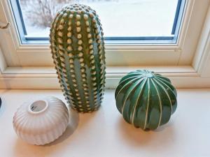 trois plantes assises sur un rebord de fenêtre à côté d’un cactus dans l'établissement 4 person holiday home in GRISSLEHAMN, à Grisslehamn