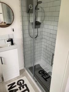 um chuveiro com uma porta de vidro na casa de banho em Farr North Lodge 2 With Hot-Tub em Wick