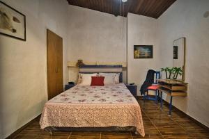 a bedroom with a bed and a table and a chair at Casa Charlie in Areguá