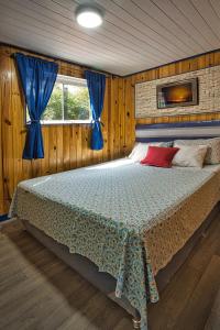 a bedroom with a large bed with blue curtains at Casa Charlie in Areguá