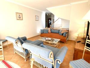 een woonkamer met blauwe banken en een bank bij Vila Falesia Penthouse in Albufeira