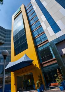 um edifício amarelo com um guarda-chuva em frente em BelAir Business Mexico City WTC, Trademark by Wyndham em Cidade do México