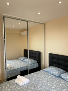 a bedroom with two beds and a mirror at Neraida Central Apartment in Loutraki