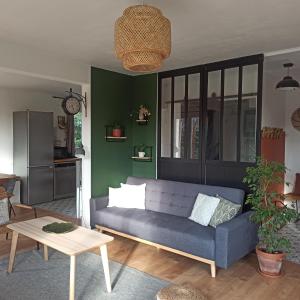 a living room with a blue couch and a table at La Tanière aux Loups in Montévrain