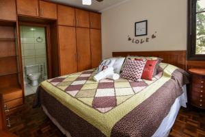 - une chambre avec un lit doté d'un ours en peluche dans l'établissement Rosa Edifício Bavária, à Gramado