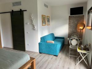 een woonkamer met een blauwe stoel en een bed bij Marimastè in Roncade