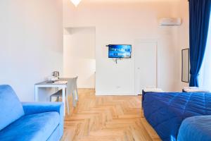 Toto e Peppino luxury rooms في نابولي: غرفة معيشة مع أريكة زرقاء وطاولة
