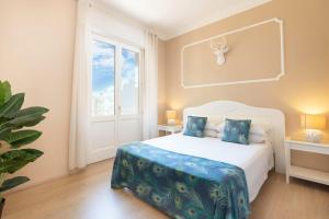 a bedroom with a white bed and a window at Colibrì Prestige Rooms - Roman Ruins View in Cagliari
