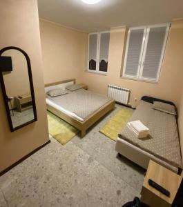 Habitación pequeña con 2 camas y espejo. en Przystań Rudniki, 