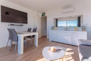 salon ze stołem i kuchnią w obiekcie Apartment With Panoramic Sea View, Walk To The Beach - Maréchal Juin by Halldis w Cannes