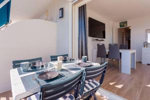 jadalnia ze stołem z krzesłami i telewizorem w obiekcie Apartment With Panoramic Sea View, Walk To The Beach - Maréchal Juin by Halldis w Cannes +7 zdjęć