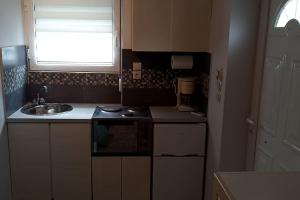 uma pequena cozinha com um lavatório e uma janela em Paris house 4 em Patra