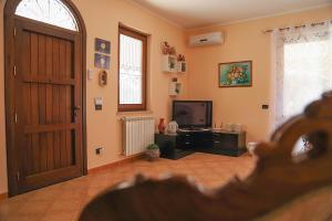 un salon avec une porte et une télévision dans l'établissement Lucy's cottage, à Cinisi