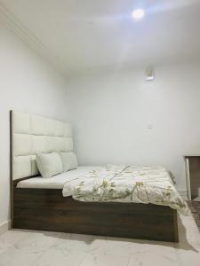 a bed in a room with a white wall at Andrea’s Home in Abuja