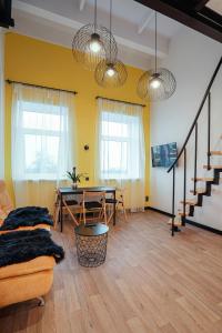 ein Wohnzimmer mit einem Tisch und einem Sofa in der Unterkunft Respublikos LOFT Forentinn in Panevėžys