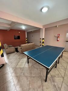 a ping pong table in a room with a living room at Thermas da Mantiqueira Hotel in Poços de Caldas