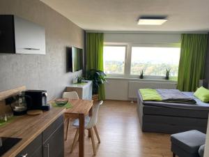 a room with a bed and a table and a kitchen at Apartment Stadtblick in Braunschweig