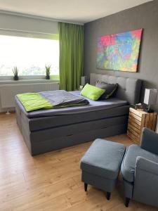 um quarto com uma cama grande e uma cadeira em Apartment Stadtblick em Braunschweig