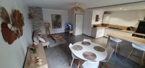 cocina y sala de estar con mesa y sillas en Logement entier de plain-pied en Épagny