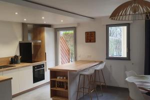 uma cozinha com um balcão, uma mesa e cadeiras em Logement entier de plain-pied em Épagny