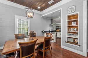 uma sala de jantar com uma mesa de madeira e cadeiras em Charming 1900s Farmhouse with Hay Meadow View em Nacogdoches