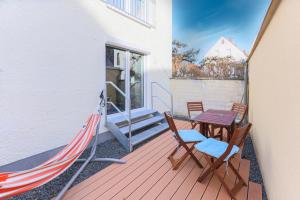porche con hamaca, mesa y sillas en Arbio I Cozy Apartments Augsburg-Lechhausen, en Augsburg