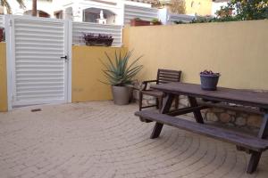 uma mesa de piquenique de madeira e duas cadeiras ao lado de uma parede em Fantástica casa con piscina y playa ,Torredembarra-Tarragona em Pobla de Montornés