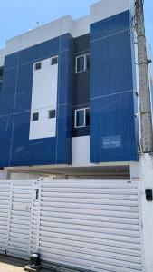 un gran edificio azul con un garaje delante en Jóia Rara pertinho da Praia!, en João Pessoa