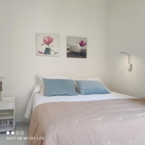 a bedroom with a white bed with three pictures on the wall at Canoa in Torrox Costa +21 photos