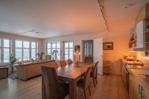 a kitchen and dining room with a wooden table and chairs at Amazing and secluded northern light apartment near sea and city! in Selnes