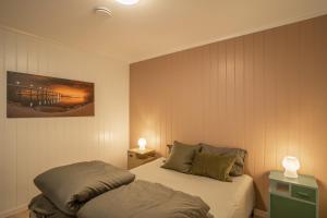 a bedroom with two beds and two lamps at Amazing and secluded northern light apartment near sea and city! in Selnes